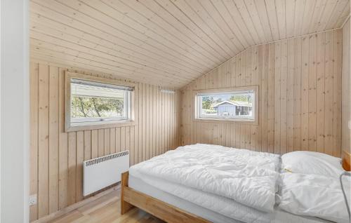 een slaapkamer met een bed in een kamer met 2 ramen bij Rino in Blåvand