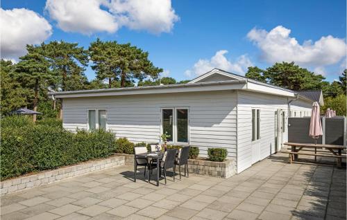 a small white shed with a table and chairs at Nice Apartment In Nexø With Wifi in Neksø