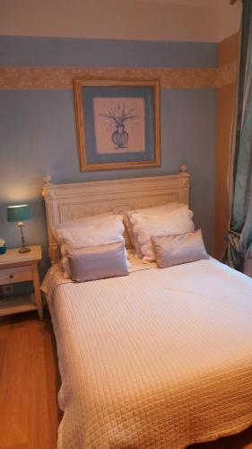 a bedroom with a bed with two pillows on it at Hotel Relais Du Postillon in Antibes