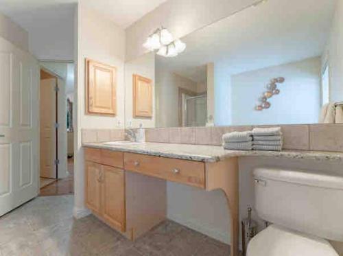 łazienka z umywalką i dużym lustrem w obiekcie 2500 sq house in Springbank Hill BL 261818 w mieście Calgary