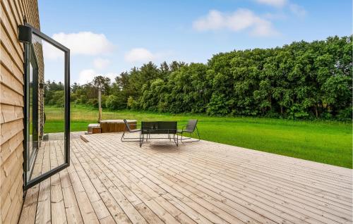 a patio with a table and chairs on a wooden deck at Amazing Home In Spøttrup With Wifi in Lihme