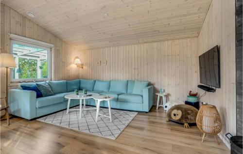 a living room with a blue couch and a table at 3 Bedroom Lovely Home In Havndal in Havndal