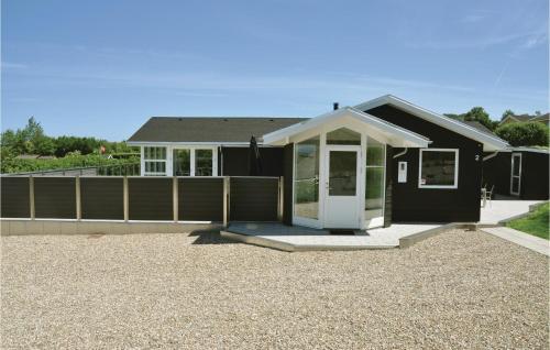 a black house with a white door on a gravel driveway at Holiday Home Kildevangsvej Asperup Ii in Asperup