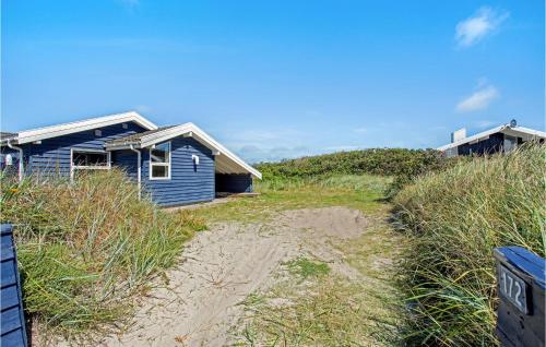 a blue house sitting on top of a beach at Pynten in Grønhøj