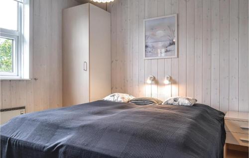 NymindegabにあるNice Home In Nrre Nebel With 3 Bedrooms, Sauna And Wifiのベッドルーム1室(大型ベッド1台、青い毛布付)
