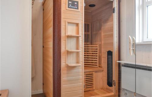 NymindegabにあるNice Home In Nrre Nebel With 3 Bedrooms, Sauna And Wifiの木製クローゼット(時計付)が備わる客室です。