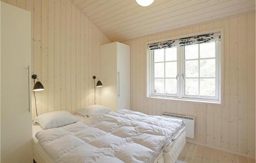 Vester SømarkenにあるCozy Home In Aakirkeby With Wifiのベッドルーム(大きな白いベッド1台、窓付)