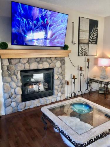 a living room with a fireplace and a tv at 2500 sq house in Springbank Hill BL 261818 in Calgary
