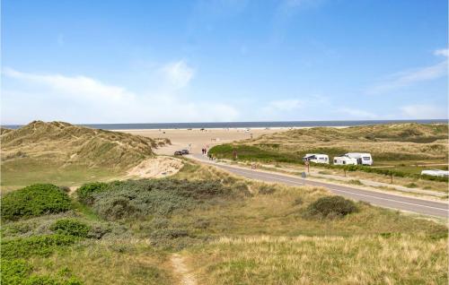a road in the middle of a field with a beach at Holiday Home Lakolk Denmark Iii in Rømø