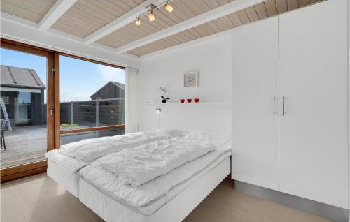 biała sypialnia z łóżkiem i dużym oknem w obiekcie Amazing Home In Rm With House A Panoramic View w mieście Bolilmark