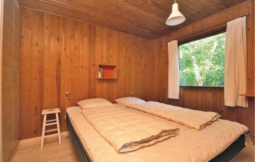 een groot bed in een houten kamer met een raam bij Beautiful Home In Fan With Wifi in Fanø