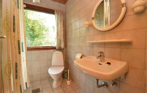 een badkamer met een wastafel, een toilet en een spiegel bij Beautiful Home In Fan With Wifi in Fanø