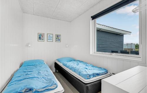 a room with two beds and a window at Kis in Fanø