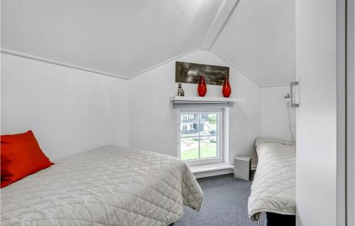een slaapkamer met een bed en een raam met rode vazen bij Awesome Apartment In Bogense With House Sea View in Bogense