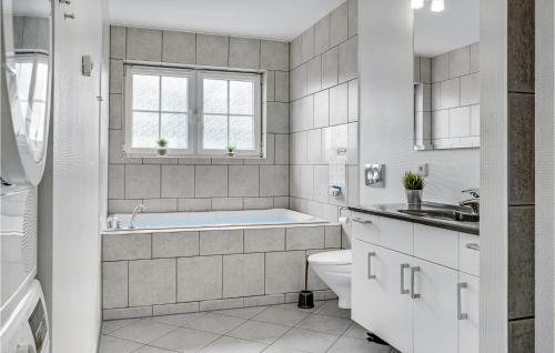 a bathroom with a tub and a toilet and a sink at Awesome Apartment In Bogense With House Sea View in Bogense