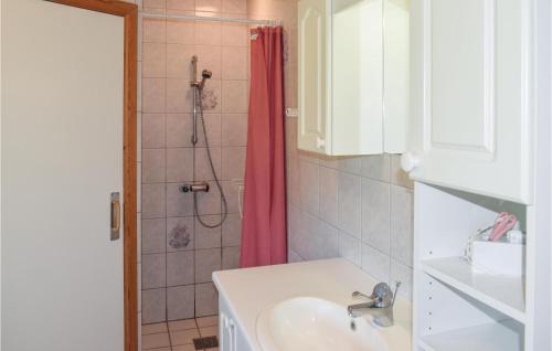 La salle de bains est pourvue d'un lavabo et d'une douche avec rideau de douche rouge. dans l'établissement 3 Bedroom Lovely Home In Humble, à Humble