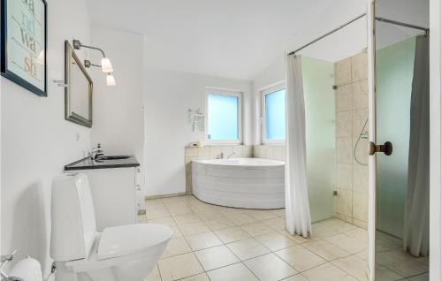 ein weißes Bad mit einer Badewanne und einem WC in der Unterkunft Amazing Home In Brovst With Kitchen in Brovst