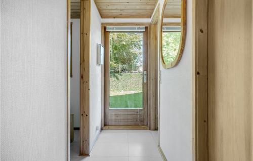 an empty hallway with a door and a window at Amazing Home In Kirke Hyllinge With Kitchen in Sæby
