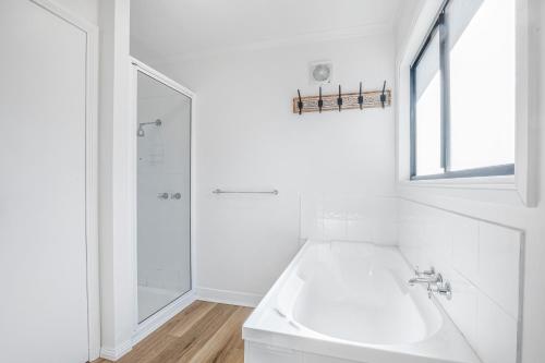 a white bathroom with a sink and a shower at Pine View Cottage in Bright