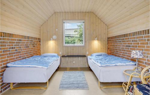 2 camas en una habitación con una pared de ladrillo en 3 Bedroom Cozy Home In Glesborg, en Fjellerup Strand