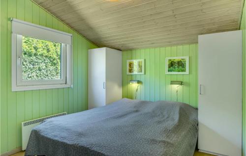 Schlafzimmer mit grünen Wänden und einem Bett mit Fenster in der Unterkunft Cozy Home In Gilleleje With Indoor Swimming Pool in Gilleleje