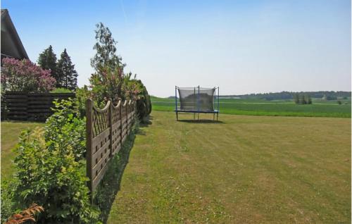a garden with a fence and a swing at Beautiful Home In Klemensker With Wifi in Klemensker