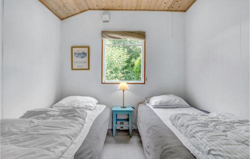 duas camas num quarto com um candeeiro sobre uma mesa em Awesome Home In Fllenslev With Kitchen em Eskebjerg