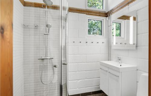 baño blanco con ducha y lavamanos en Nice Home In Aakirkeby With Wifi, en Vester Sømarken