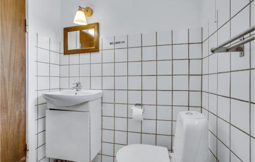 Baño de azulejos blancos con aseo y lavamanos en Awesome Home In Fllenslev With Kitchen, en Eskebjerg