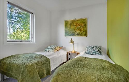 Duas camas num quarto com uma janela em 2 Bedroom Beautiful Home In Grsted em Græsted