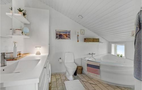 a bathroom with a tub and a toilet and a sink at Strandhus in Bolilmark