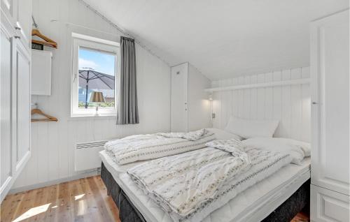 BolilmarkにあるStrandhusの白いベッドルーム(大型ベッド1台、窓付)
