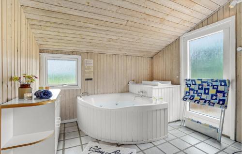 KlegodにあるAmazing Home In Ringkbing With 5 Bedrooms, Sauna And Wifiの木製の壁のバスルーム(バスタブ付)