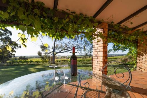 a table with a bottle of wine on a patio at Blickinstal Holiday Retreat in Bethany