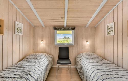 BjerregårdにあるSpar Toのベッド2台、椅子、窓が備わる客室です。