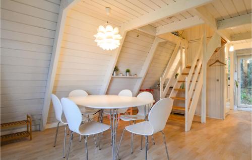 a dining room with a table and white chairs at Studio Holiday Home In Knebel in Knebel