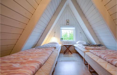 a attic room with three beds and a window at Beautiful Home In Knebel With Outdoor Swimming Pool in Knebel