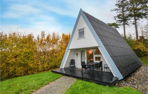 a small white house with a black roof at Studio Holiday Home In Knebel in Knebel