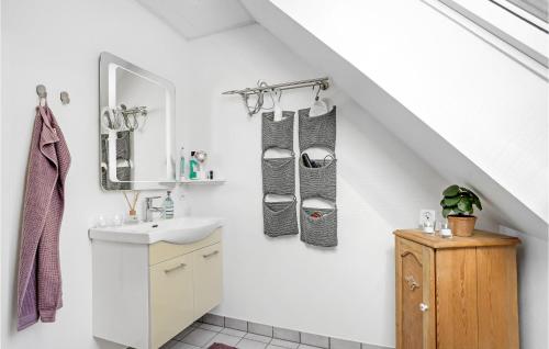 uma casa de banho branca com um lavatório e um espelho em 2 Bedroom Awesome Apartment In Klemensker em Klemensker