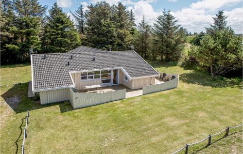 a small house on a lawn with a fence at Lovely Home In Hjørring With Sauna in Lønstrup