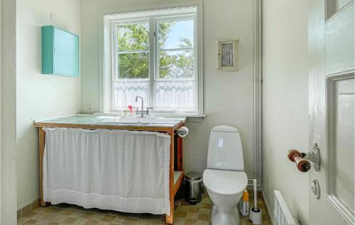 a bathroom with a toilet and a sink and a window at Gorgeous Home In Gudhjem With Wifi in Gudhjem