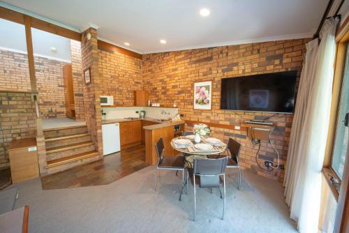 a kitchen and dining room with a table and a television at Blickinstal Holiday Retreat in Bethany