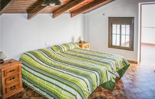 エル・ガストルにあるStunning Home In El Gastor With 3 Bedrooms, Wifi And Outdoor Swimming Poolのベッドルーム1室(ベッド1台、緑と黄色の毛布付)