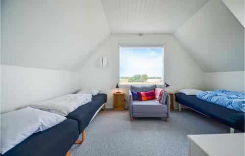 een slaapkamer met 2 bedden, een stoel en een raam bij Amazing Home In Ebeltoft With Kitchen in Ebeltoft
