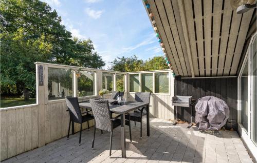 un patio avec une table et des chaises sur une terrasse dans l'établissement Two-Bedroom Holiday Home In Skjern, à Halby