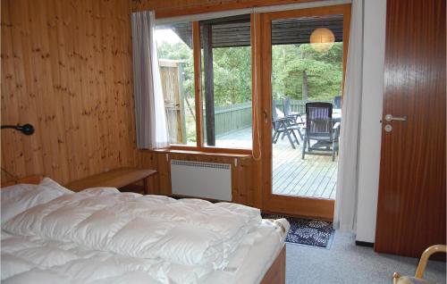 ホにある3 Bedroom Beautiful Home In Blvandのベッドルーム1室(ベッド1台付)、スライド式ガラスドアが備わります。