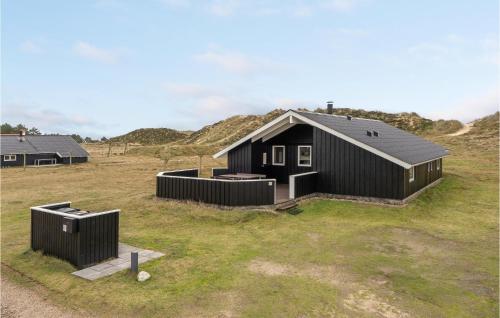 a black house on top of a grass field at Holiday Home Præstemarken Fanø Denm in Sønderho