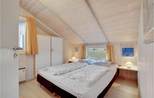 SønderhoにあるAwesome Home In Fan With 3 Bedrooms, Sauna And Wifiの大きな窓付きの客室の大型ベッド1台分です。