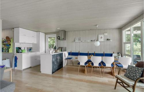 a kitchen with white cabinets and a table and chairs at Lovely Home In Spøttrup in Spottrup