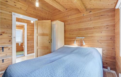 1 dormitorio con 1 cama en una cabaña de madera en Nice Home In Jgerspris With 2 Bedrooms And Wifi, en Hornsved